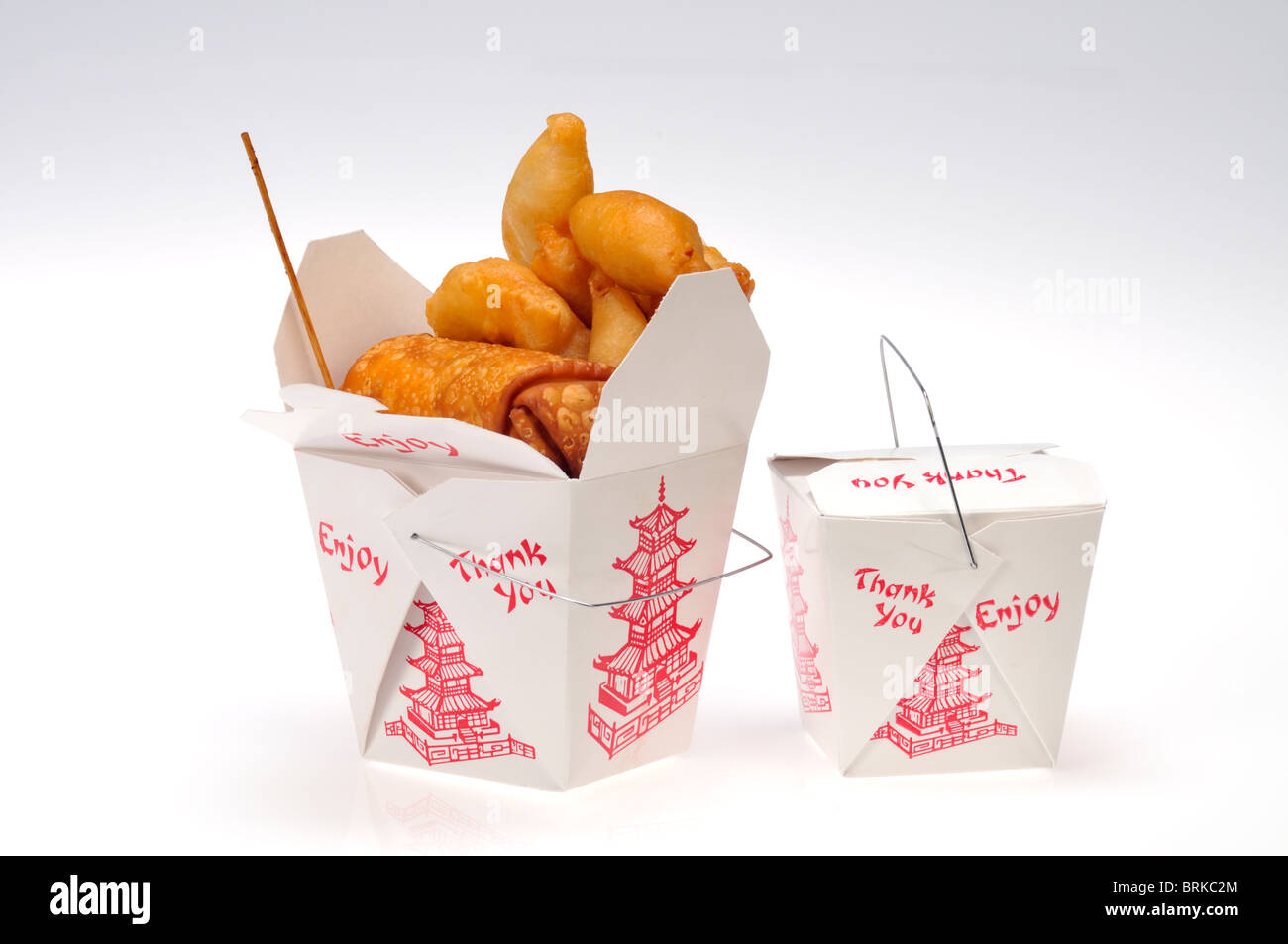 2 cartons of take away  chinese food, one open overflowing with chicken fingers & egg roll food the other closed on white background isolated. Stock Photo