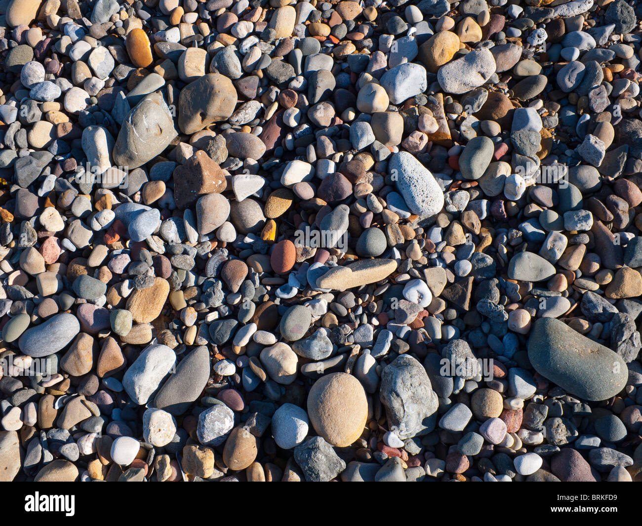 Beach pebbles cross lit by low sun light Stock Photo