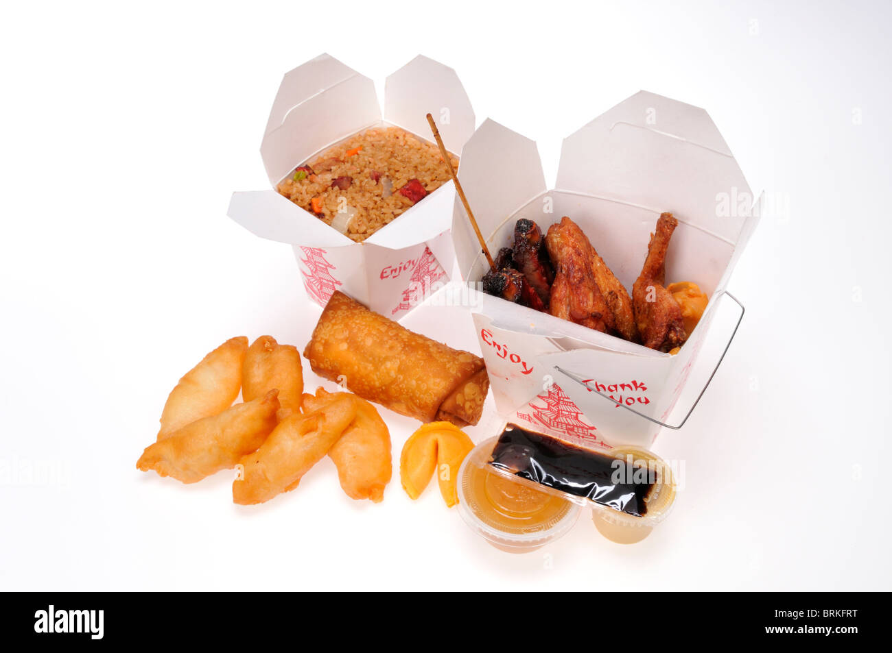 Chinese food take away meal boxes of pork fried rice, chicken fingers & wings, egg roll & beef teriyaki with dip & soy sauce. Stock Photo