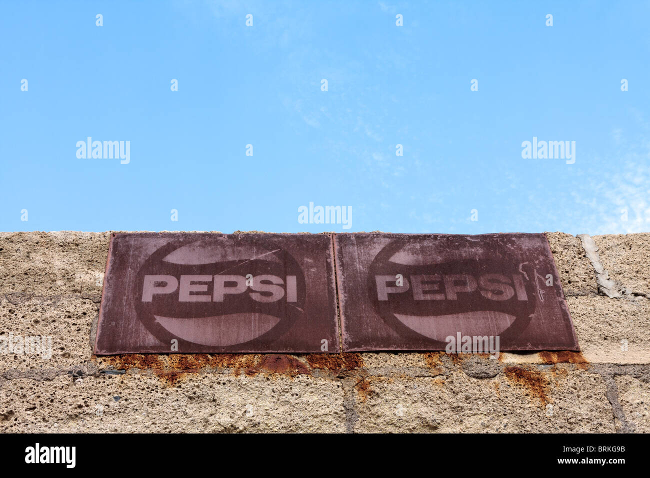 Rusty old Pepsi advertising signs on a wall against blue sky in Playa San Juan Tenerife Canary Islands Spain Stock Photo