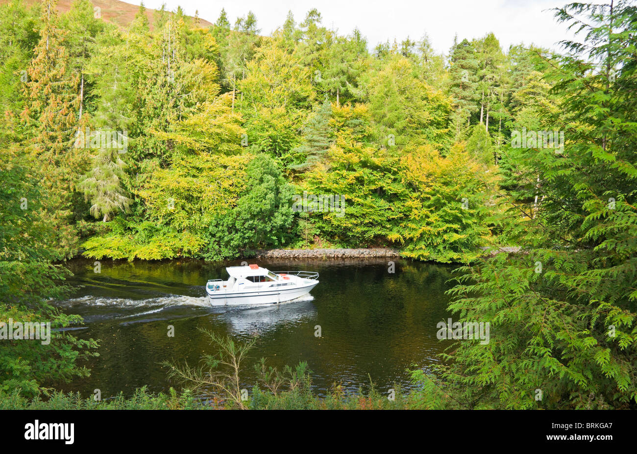 Motor boat heading north on the Caledonian Canal between Loch Lochy and Loch Oich in Highland Scotland Stock Photo