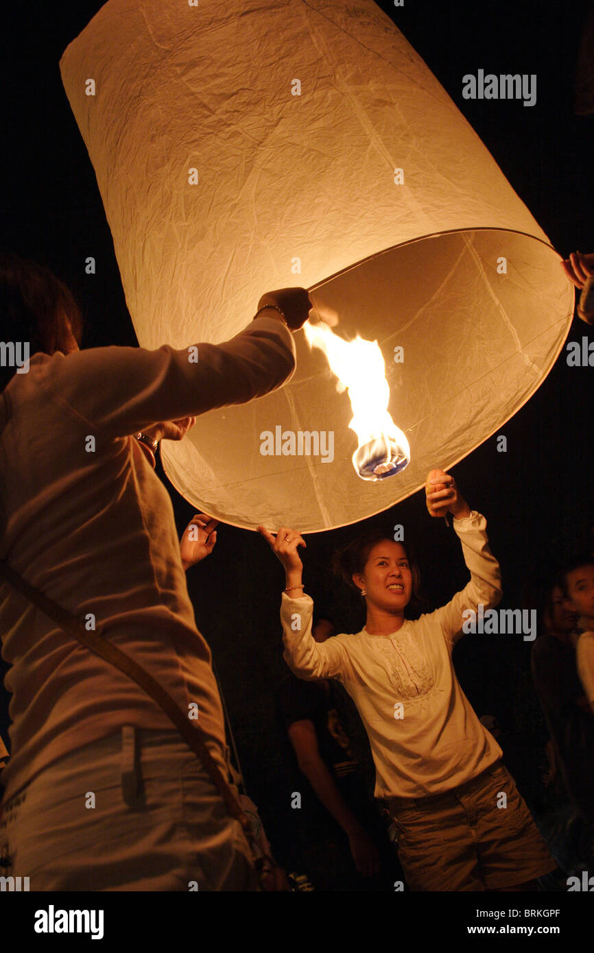 A man and a woman light a Lanna lantern (Khom Loy, Loi) at the annual Loi Krathong Festival in Chiang Mai, Thailand. Stock Photo