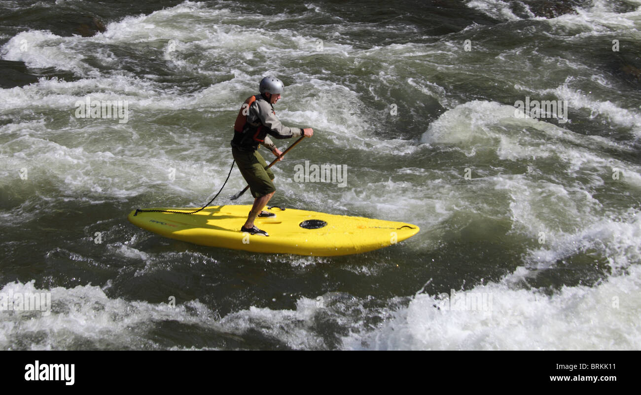 Man stands on board through rapids on the Colorado River in Glenwood Canyon in Colorado Stock Photo
