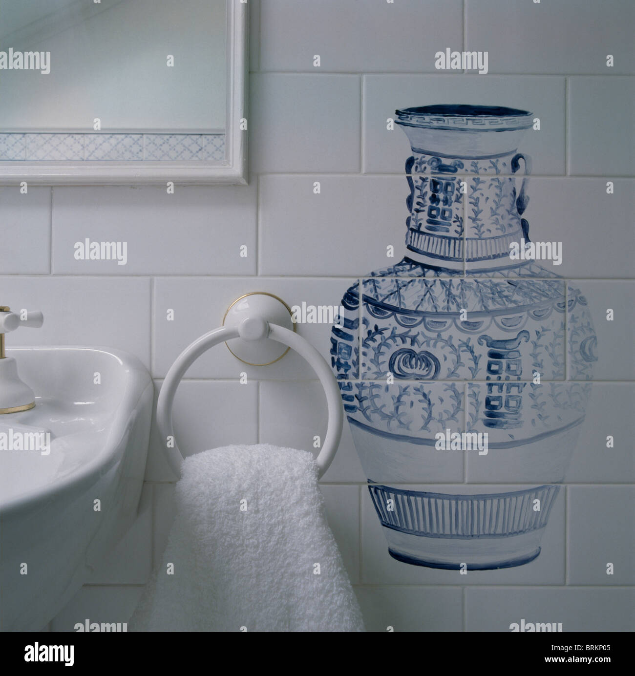 Close-up of blue+white trompe-l'oeil vase hand-painted onto white tiled bathroom wall Stock Photo