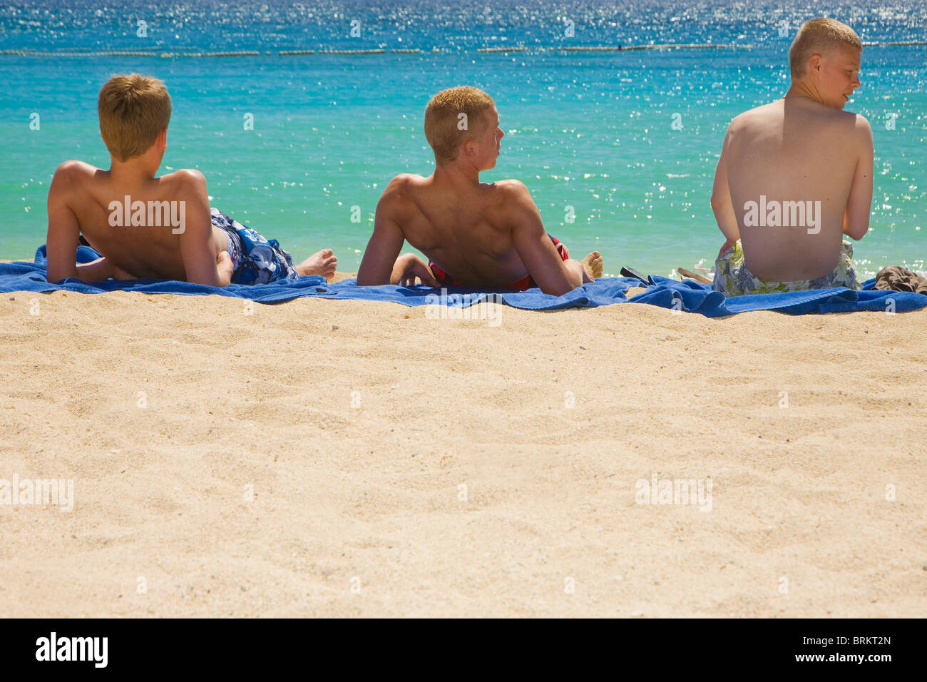 Three tourists on the beach at Amadores, Gran Canaria Stock Photo