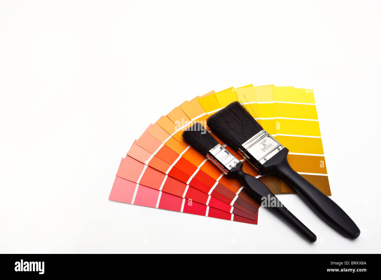 Paint brushes with red, yellow, orange and brown colour swatches Stock Photo