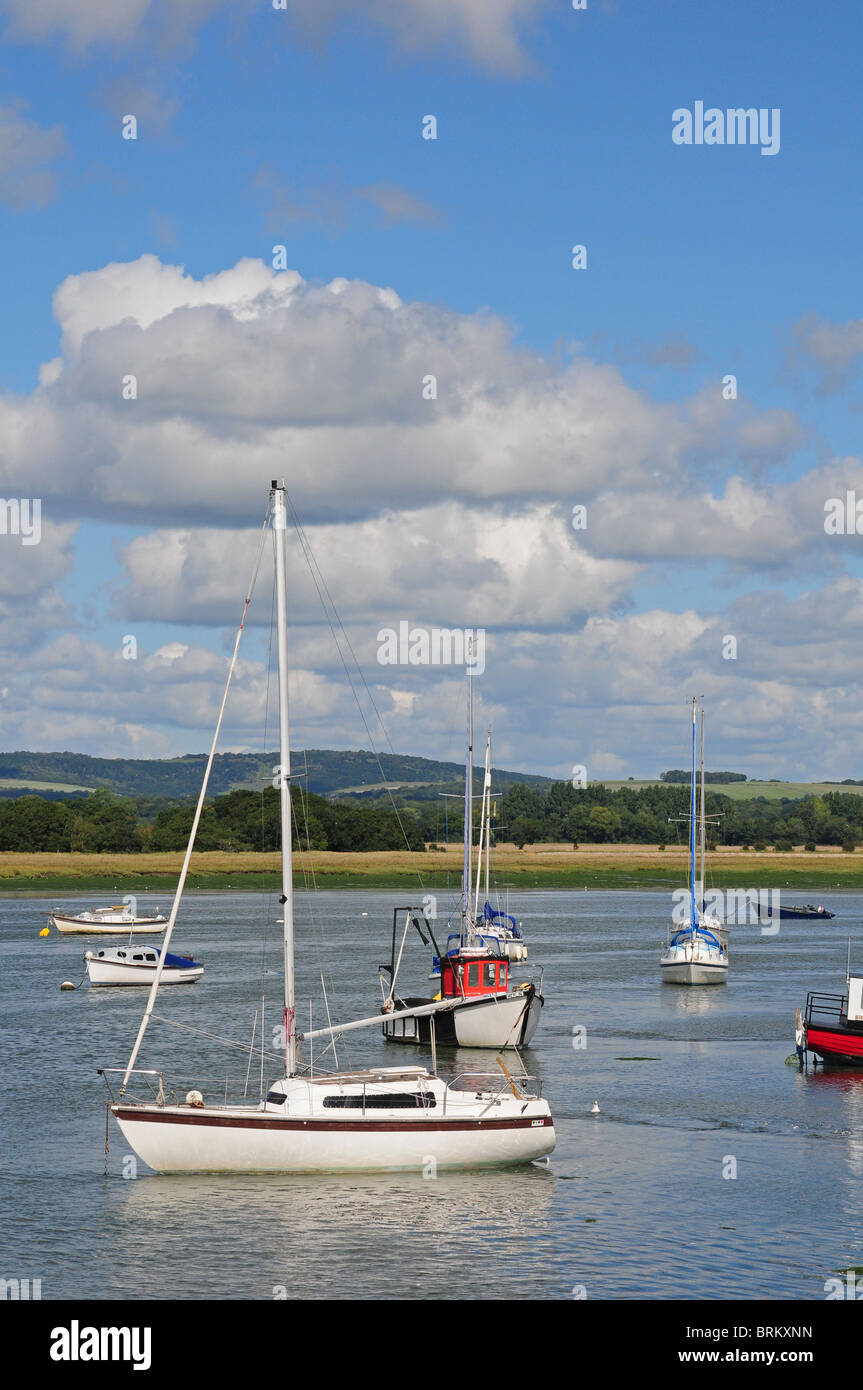 Boats at rising tide, Dell Quay. Southdowns, Kingley Vale behind. Stock Photo