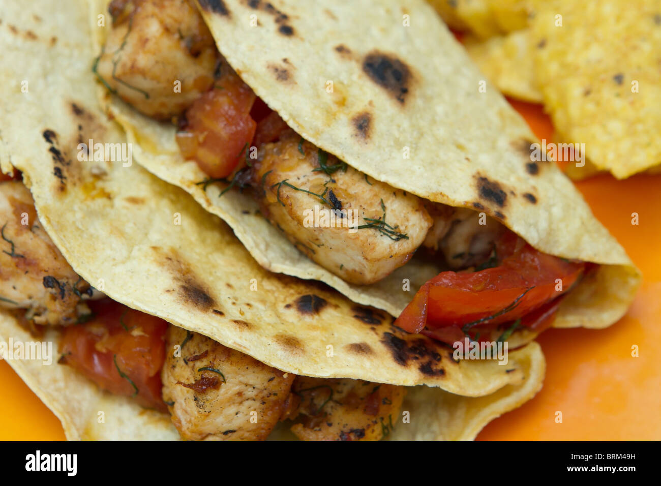 two chicken tacos with tomato and corn chips Stock Photo Alamy