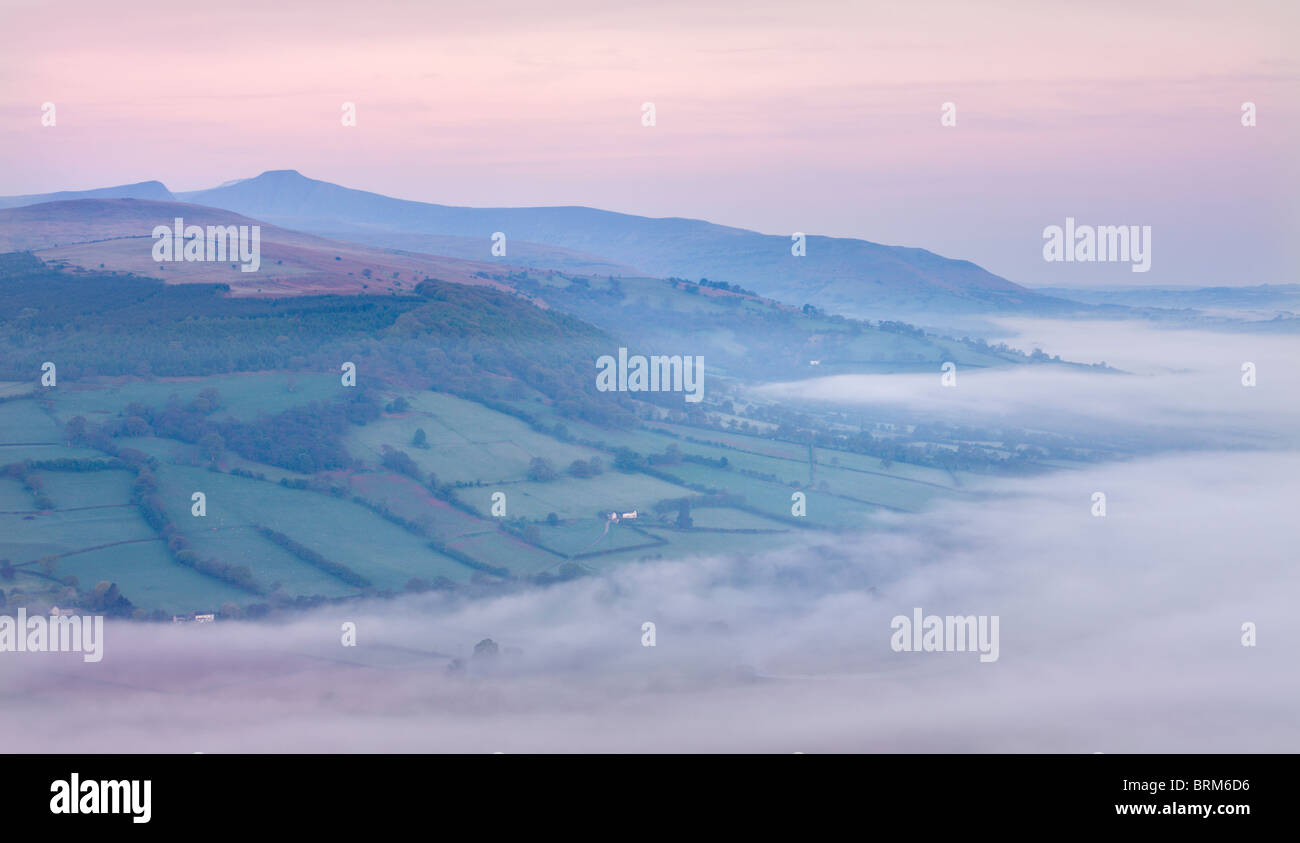 Low hanging mist shrouds the Usk Valley at dawn, viewed from the summit of Allt yr Esgair, Brecon Beacons National Park, Powys, Stock Photo