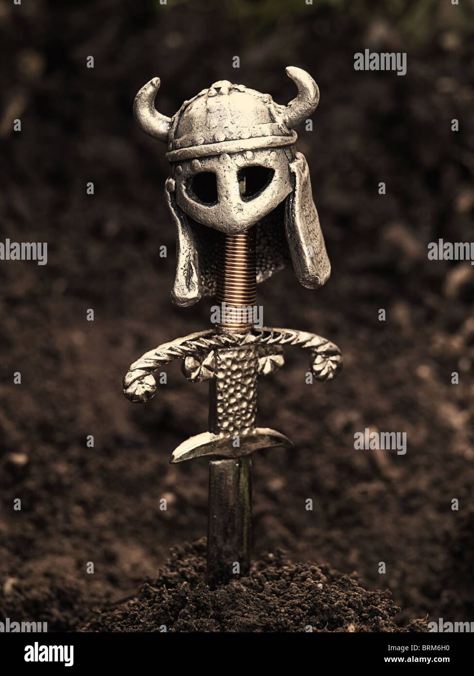 Warrior's grave with a sword and helmet instead of the cross. Sepia toned image. Stock Photo