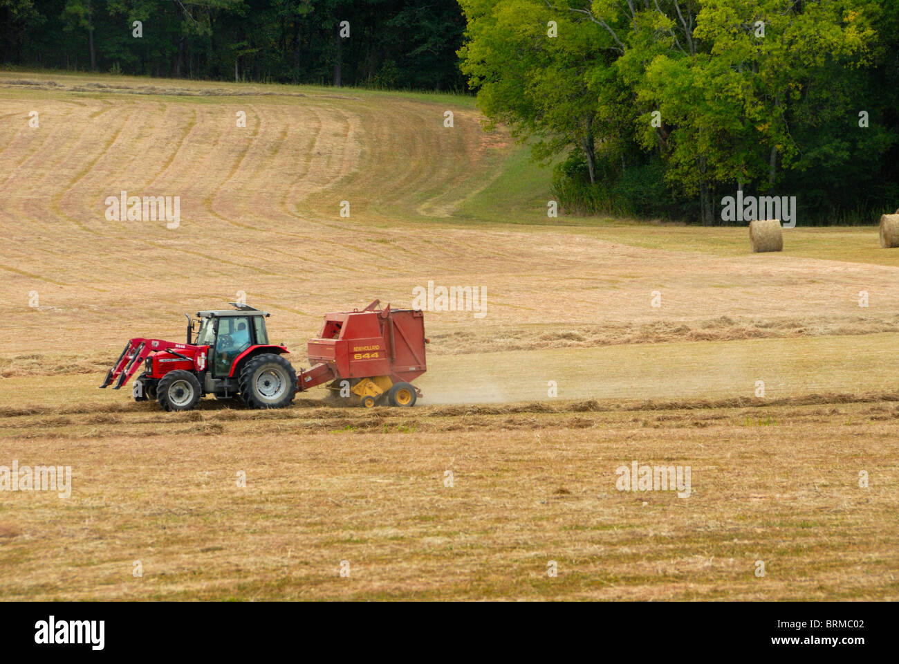 Farm tractor rolling hay bales in a Civil War battlefield, Chickamauga, GA Stock Photo