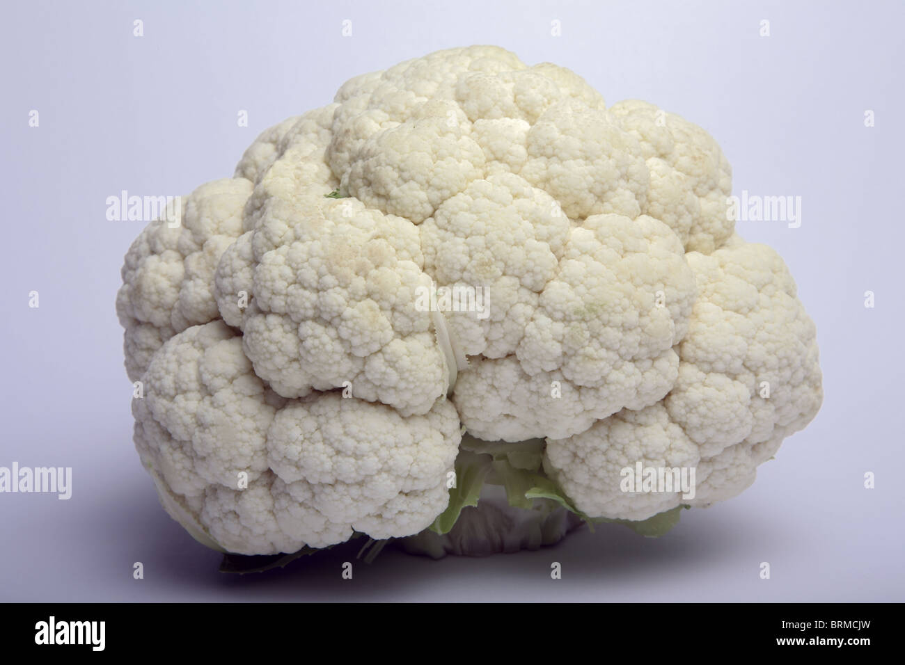 Whole cauliflower with leaves removed. Stock Photo