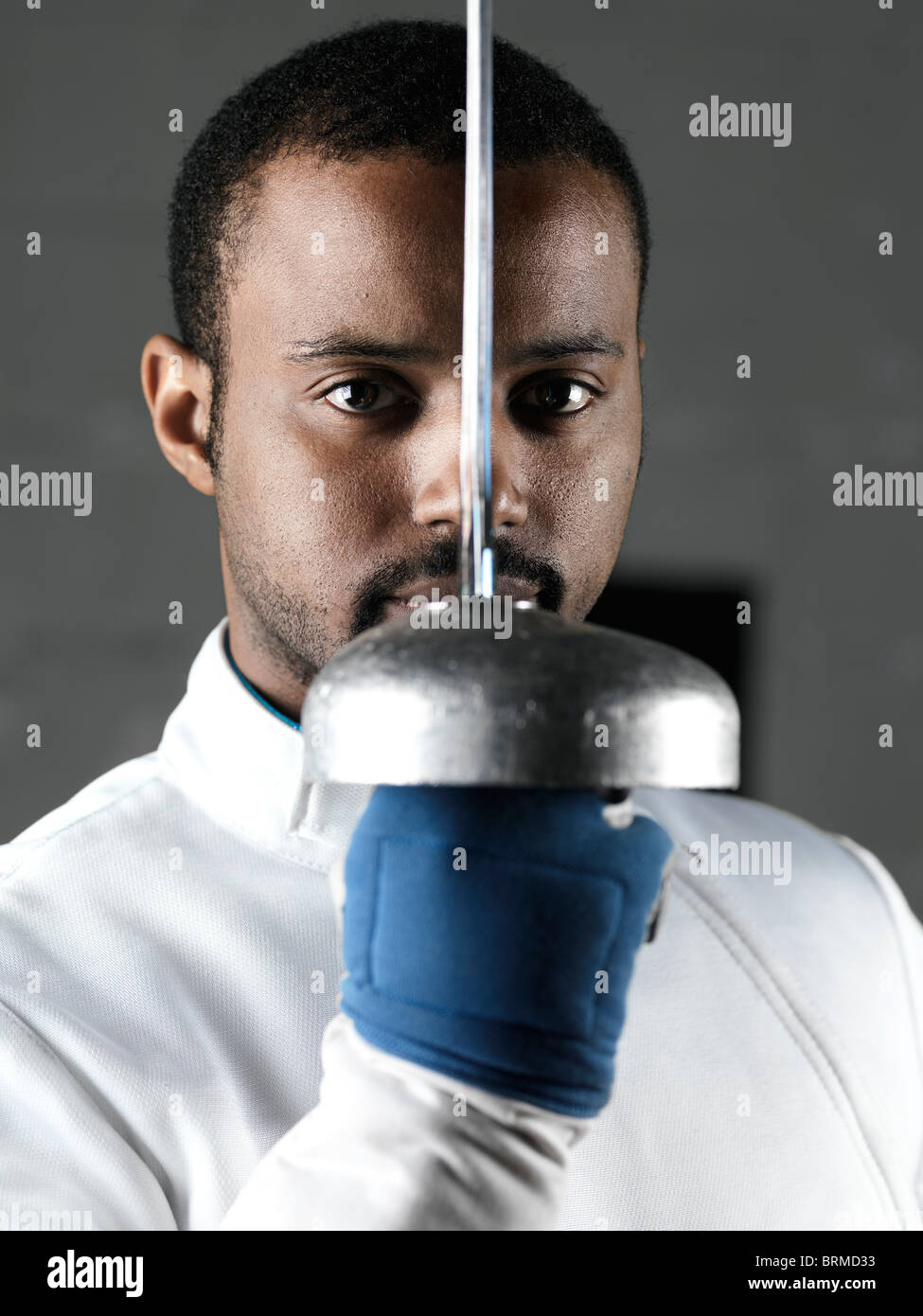 Portrait of a fencer holding an épée in front of his face Stock Photo