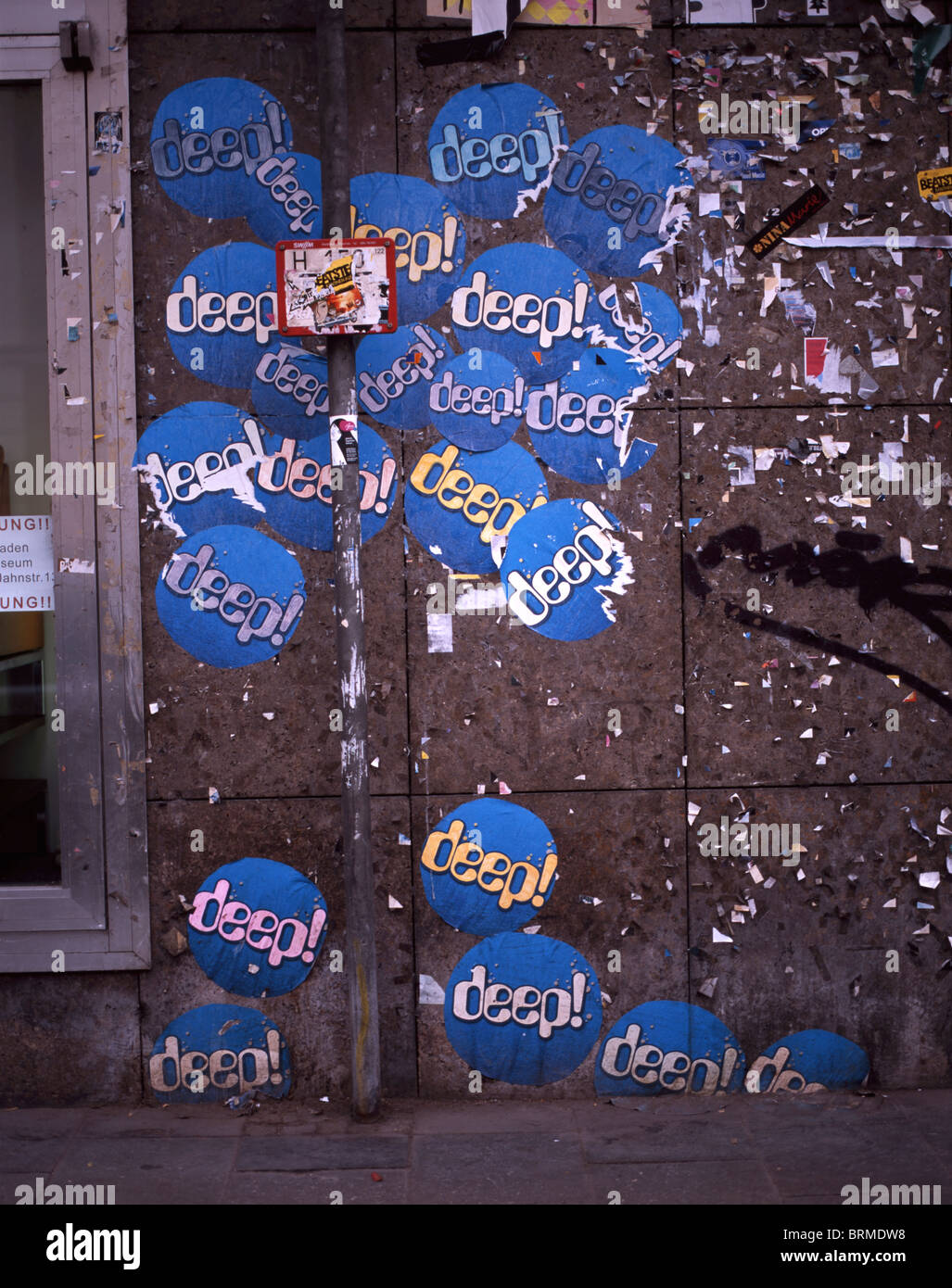 Multiple blue stickers with the writing 'deep!' glued to a wall in Munich, Germany Stock Photo