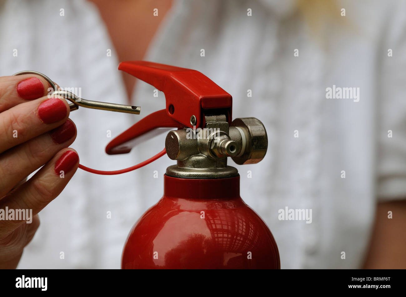 Removing the metal safety pin from a fire extinguisher Stock Photo - Alamy