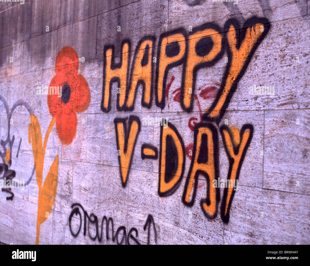 Stone wall with graffito 'Happy V-Day' together with a flower in Munich, Germany Stock Photo
