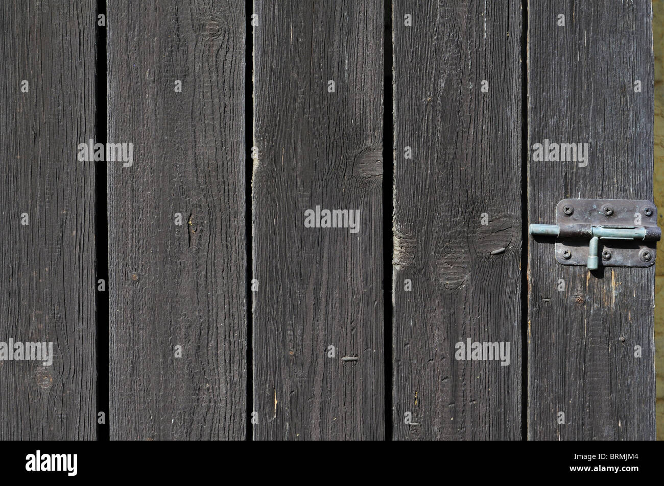 Old shabby wooden wall with a bolt. Stock Photo