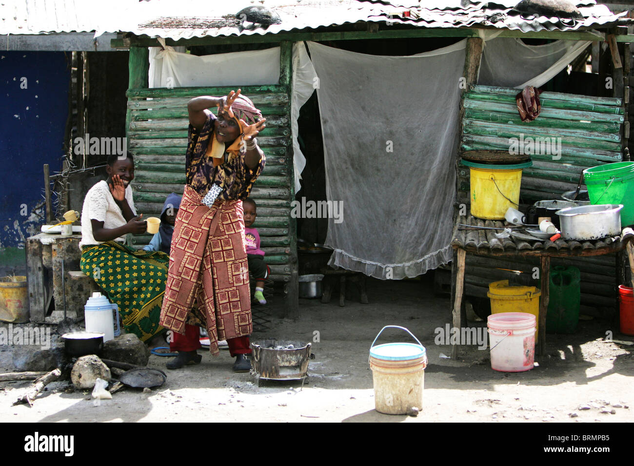 Two woman with two young children outside their makeshift dwelling Stock Photo
