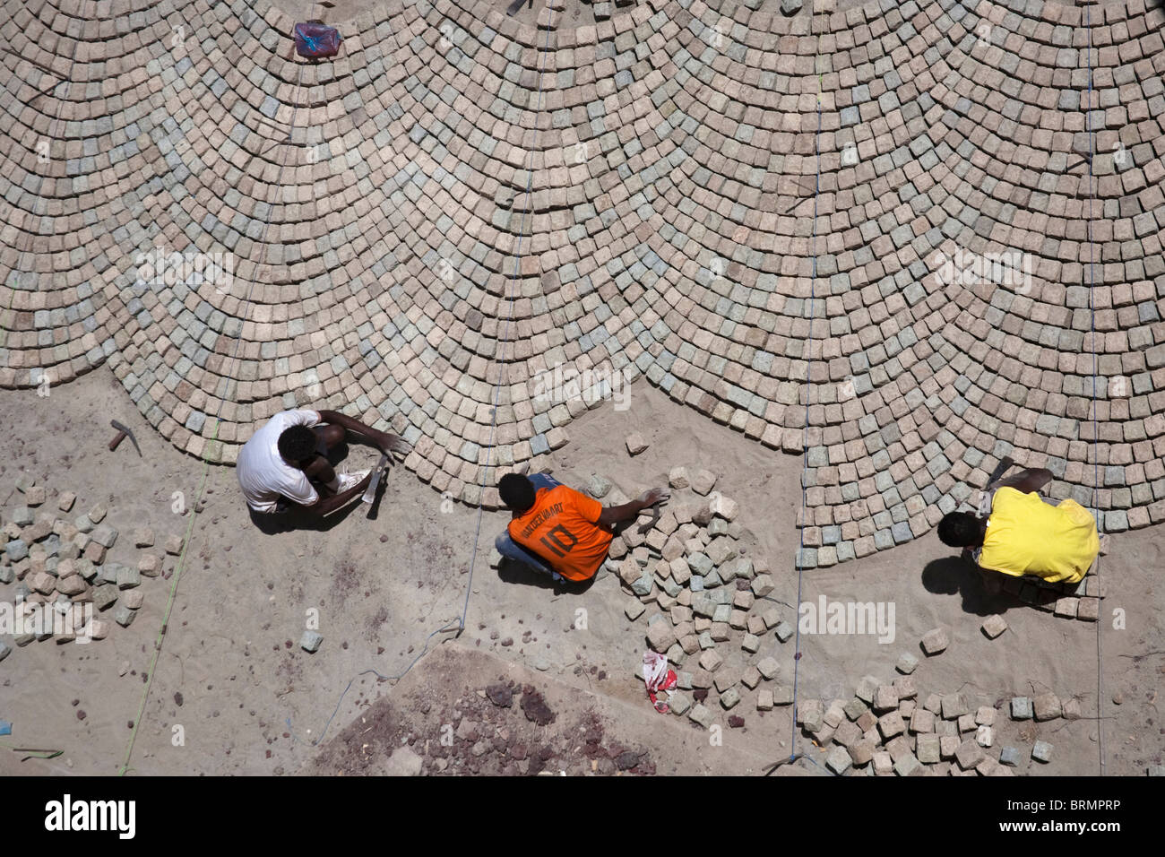 Overhead view of workers laying a cobble stone pavement in a technique learnt during Colonial times from Italian craftsmen Stock Photo