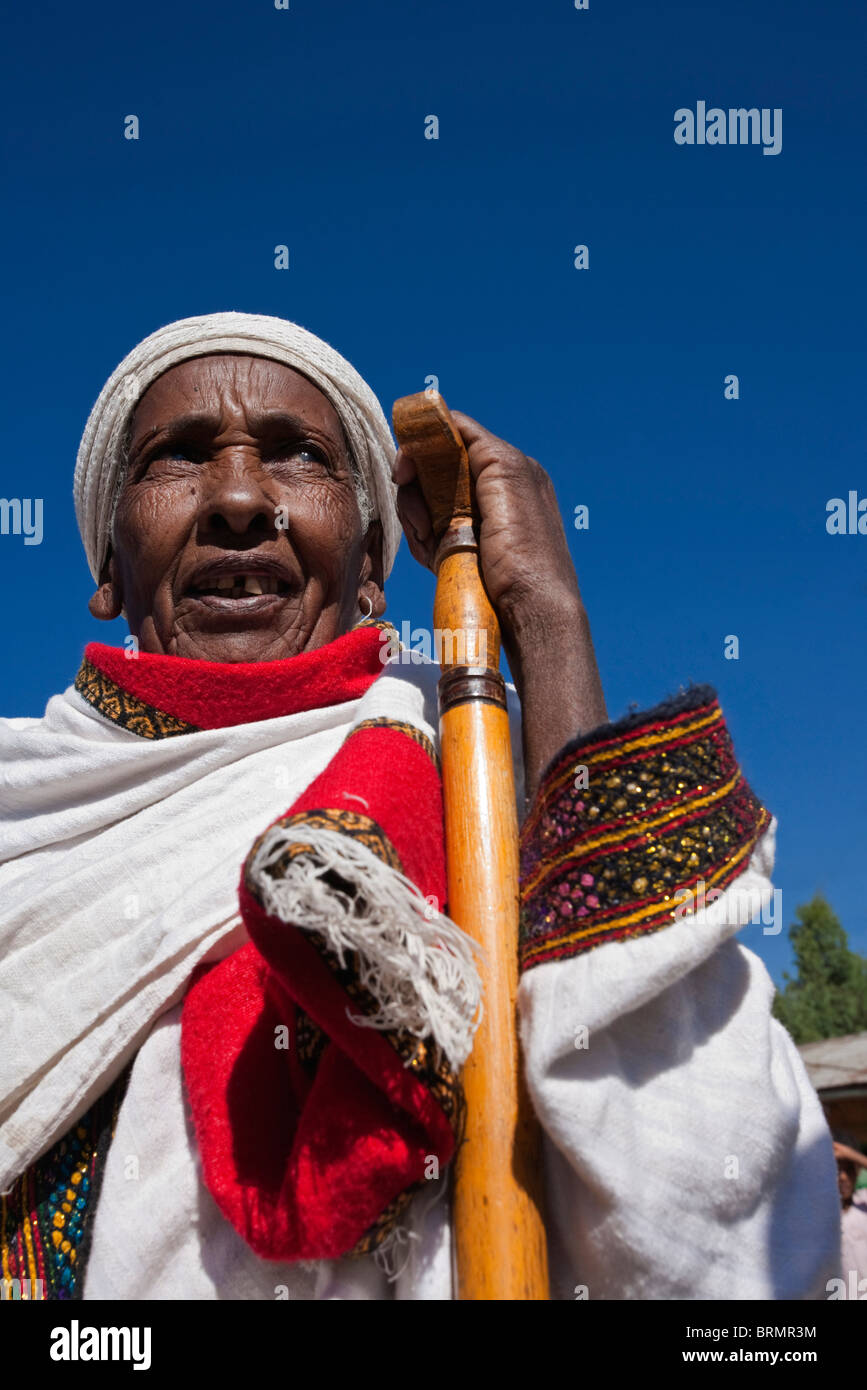 Portrait of an elderly woman in a colourful, traditional gown resting her hand on a walking stick Stock Photo