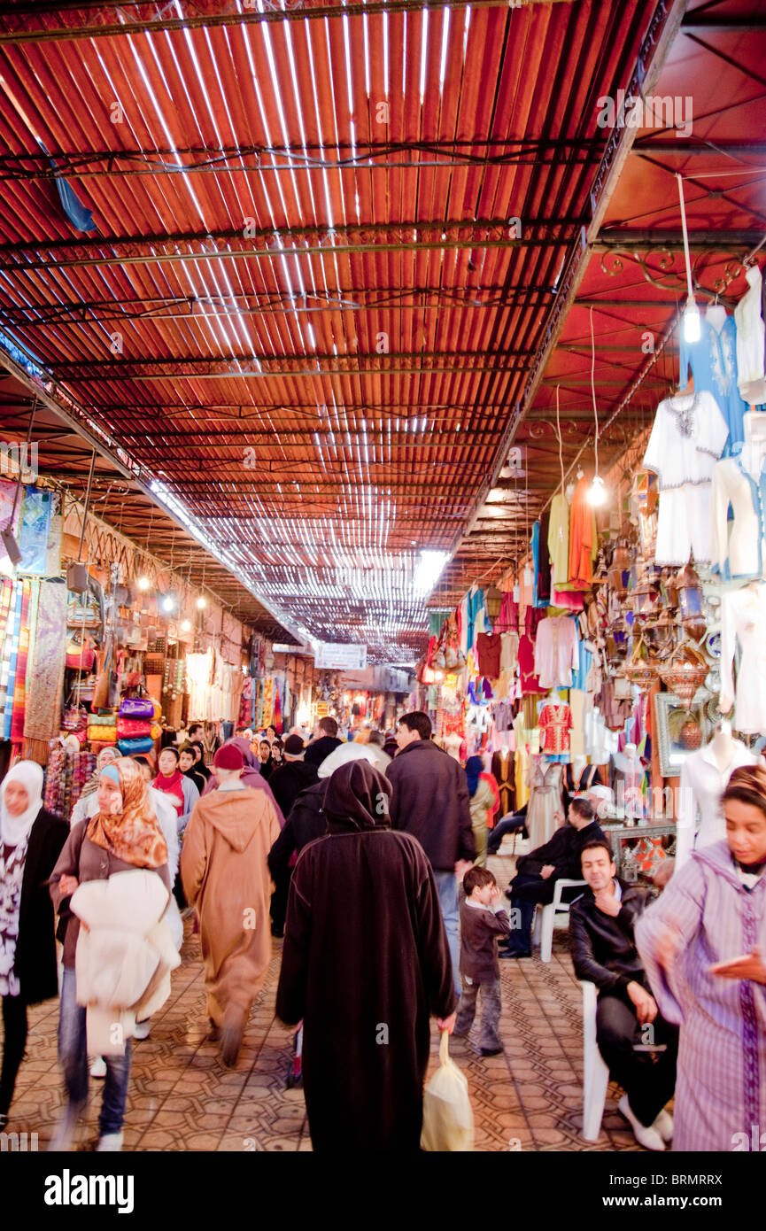 Local people shopping in one of the many narrow streets that make up the Marrakesh souk or market Stock Photo