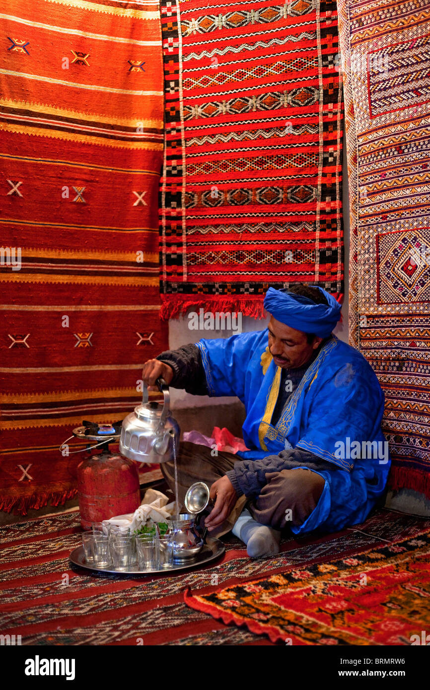 A Berber carpet maker prepares a pot of traditional tea in a Moroccan village Stock Photo
