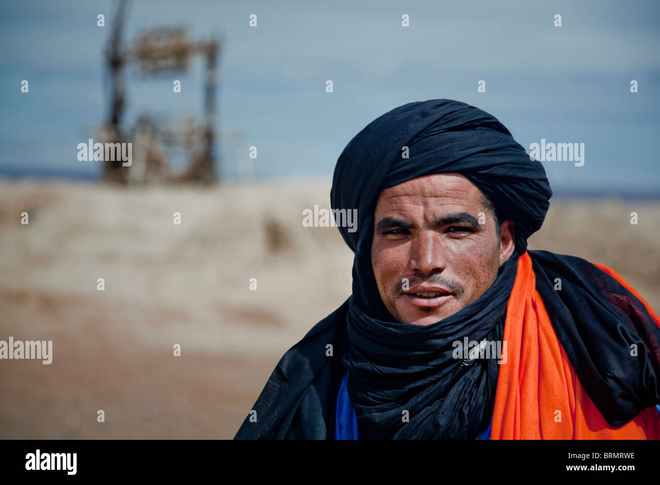 Portrait of a Berber man standing in front of an old well at a place of rest. Stock Photo