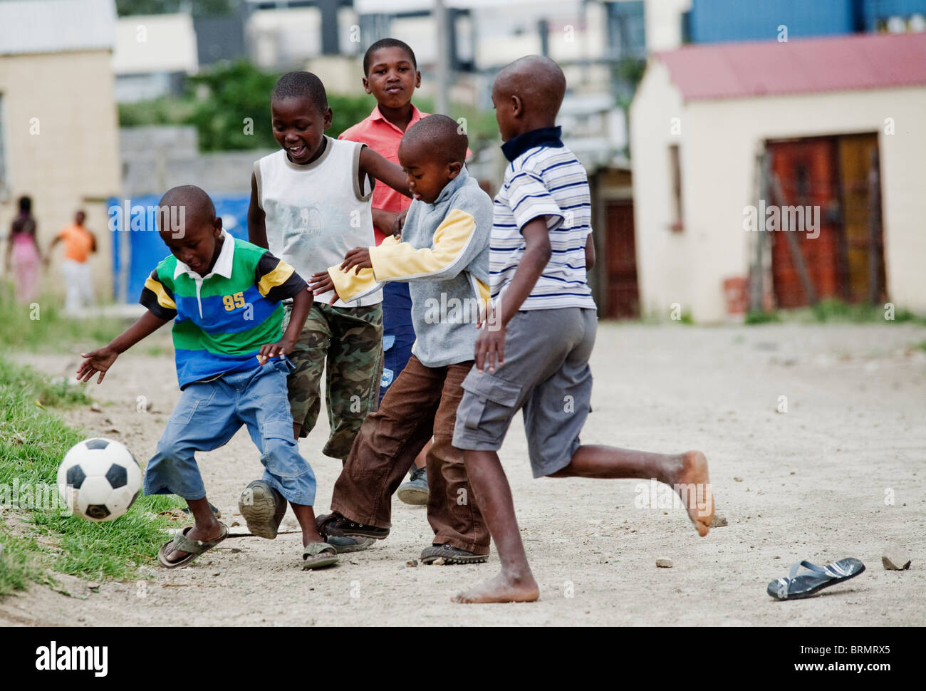 Group of young boys playing soccer in the street in Nompumulelo