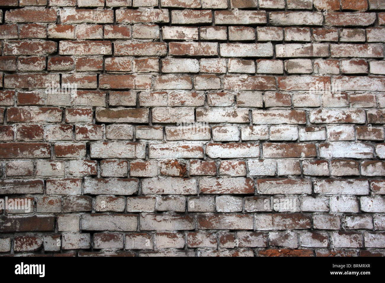 brick wall with a shabby white paint Stock Photo