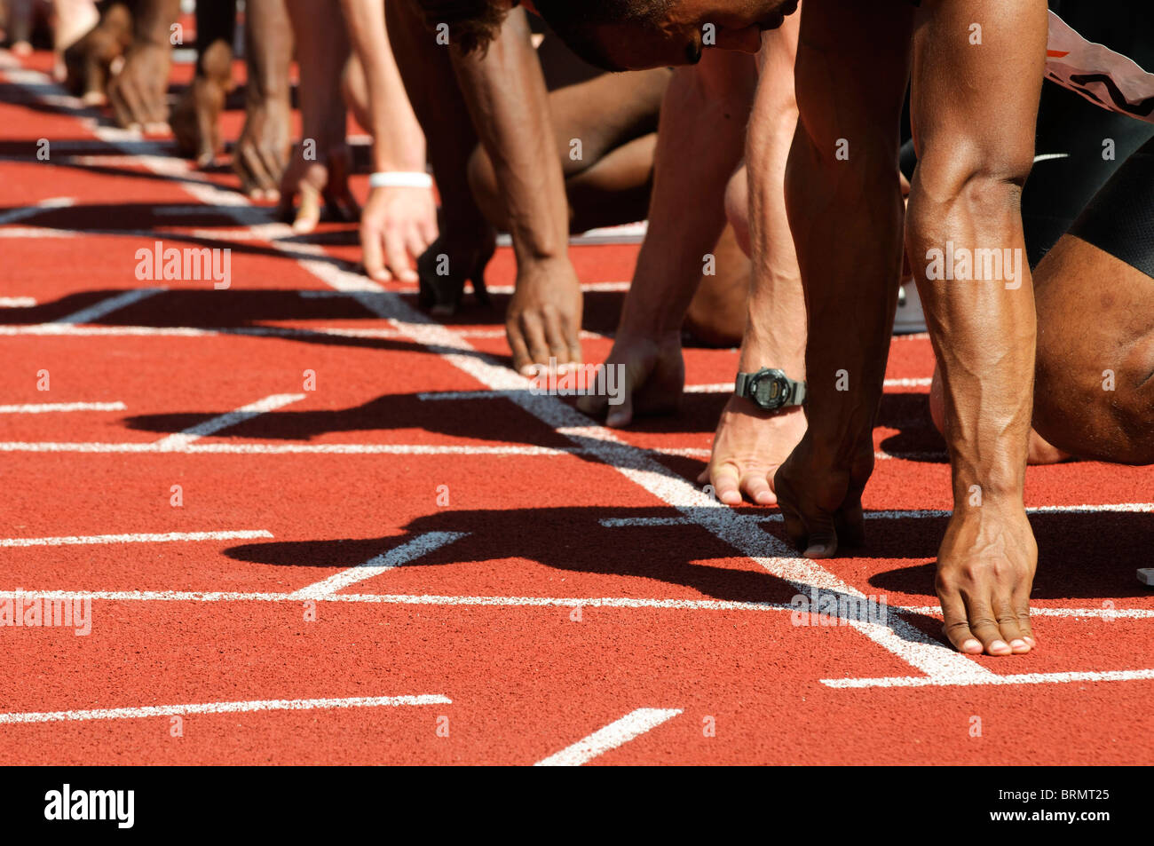 male sprinters line up their hands on the starting line at track and field event Stock Photo Alamy