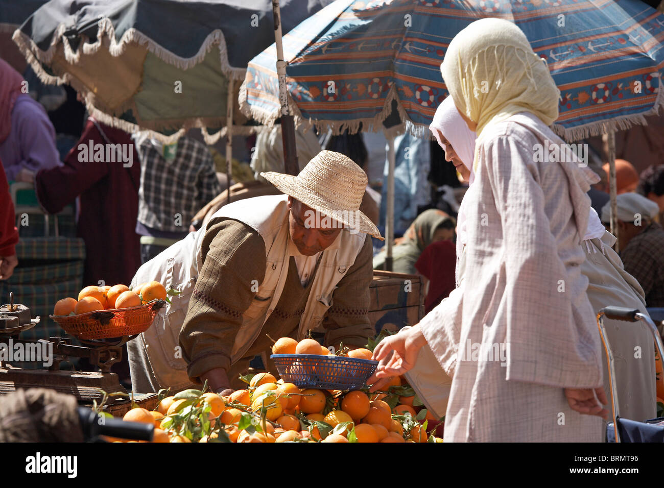 MARRAKESH: TWO MUSLIM WOMEN BUYING ORANGES IN MARKET Stock Photo