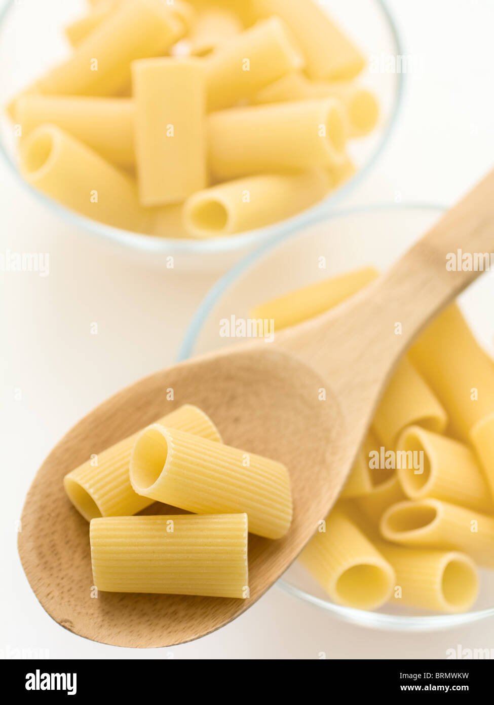 Raw italian pasta on a wooden spoon Stock Photo