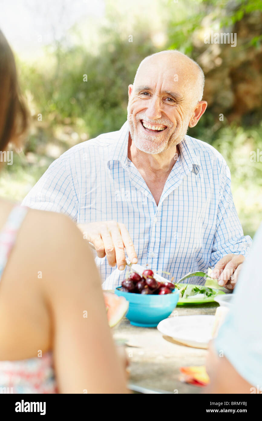 Smiling older man at picnic table Stock Photo