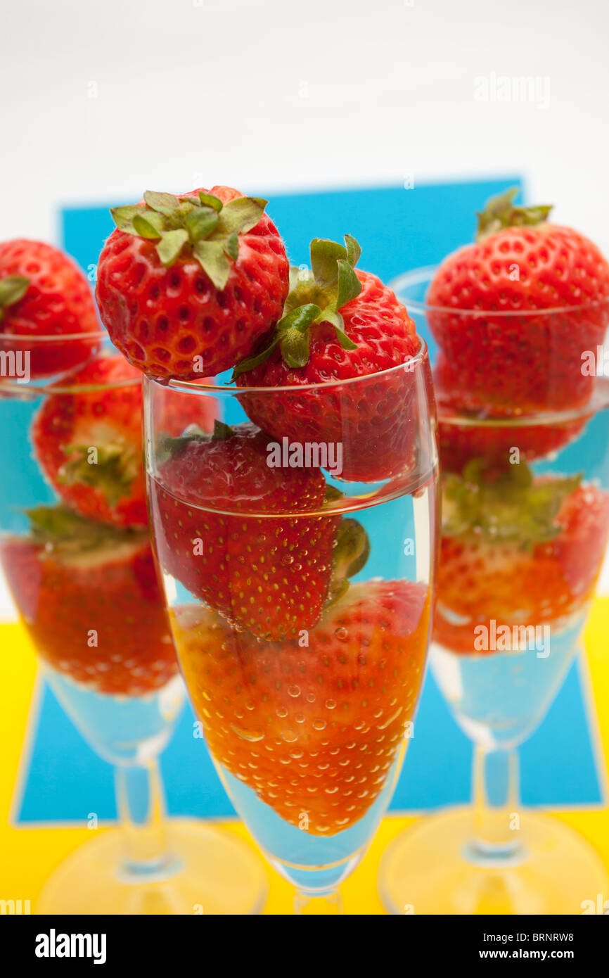 Champagne flutes containing champagne and strawberries, closeup Stock