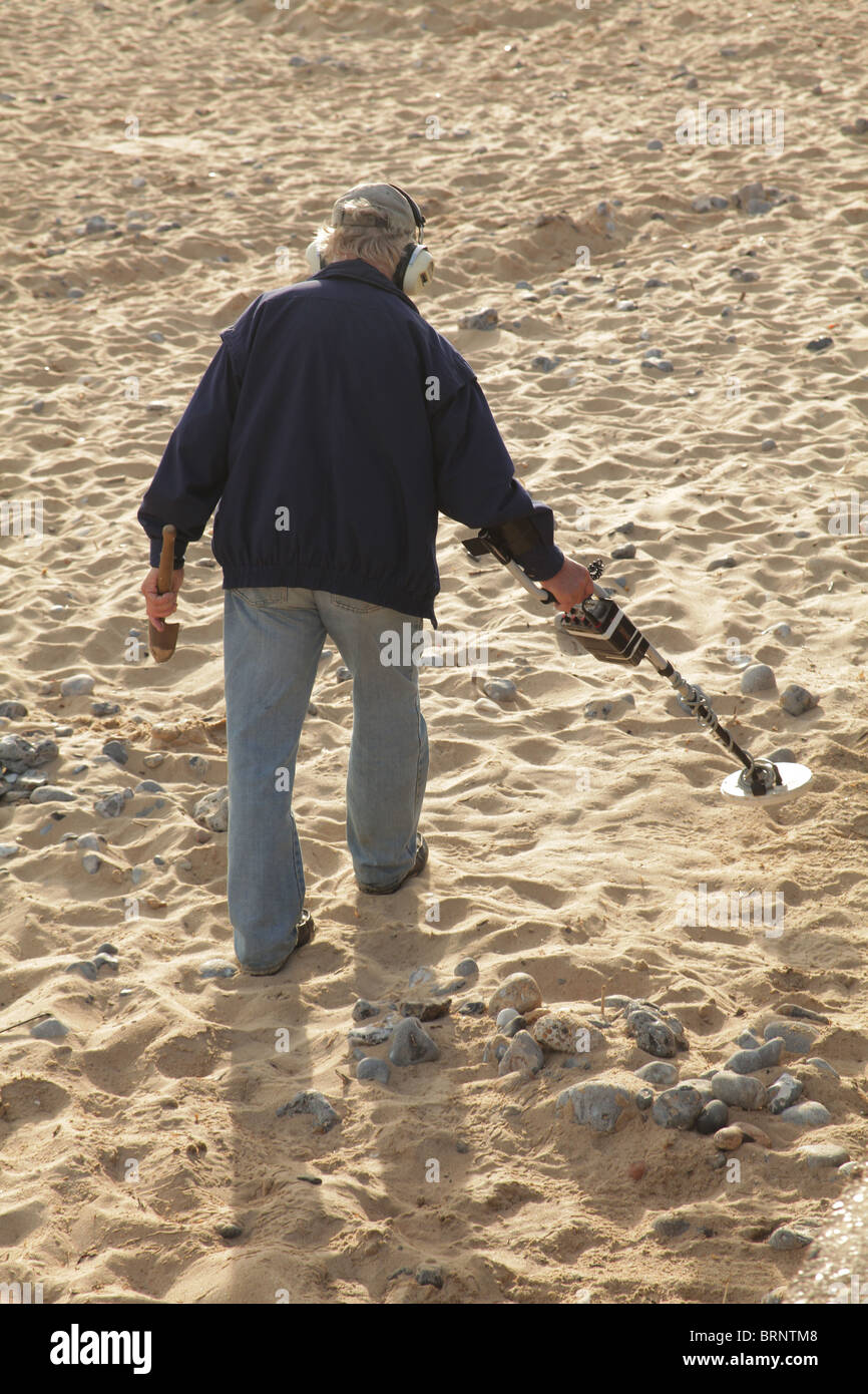 person using a metal detector on the beach Stock Photo Alamy