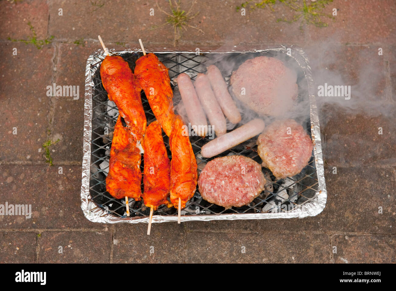 Disposable BBQ with Burgers Chicken Sausages Stock Photo Alamy