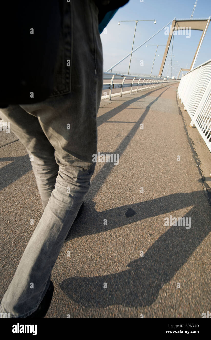 A person walking on a bridge Stock Photo