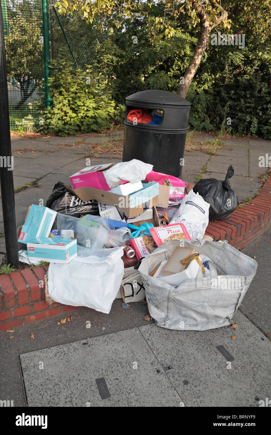 A pile of rubbish beside an overflowing bin in Hounslow, Middx, UK