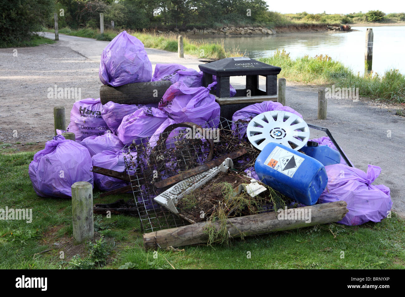 Rubbish piled around a bin waiting to be collected, Hayling Island, Hampshire, UK Stock Photo