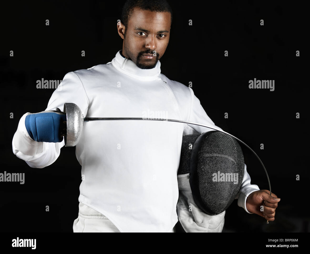 Portrait of a fencer wearing fencing uniform bending an epee in his hands. Isolated on black background Stock Photo