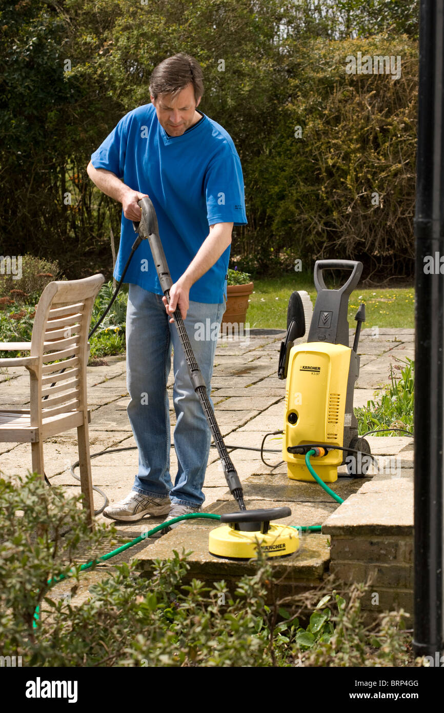 Man using a pressure washer to clean a patio Stock Photo Alamy