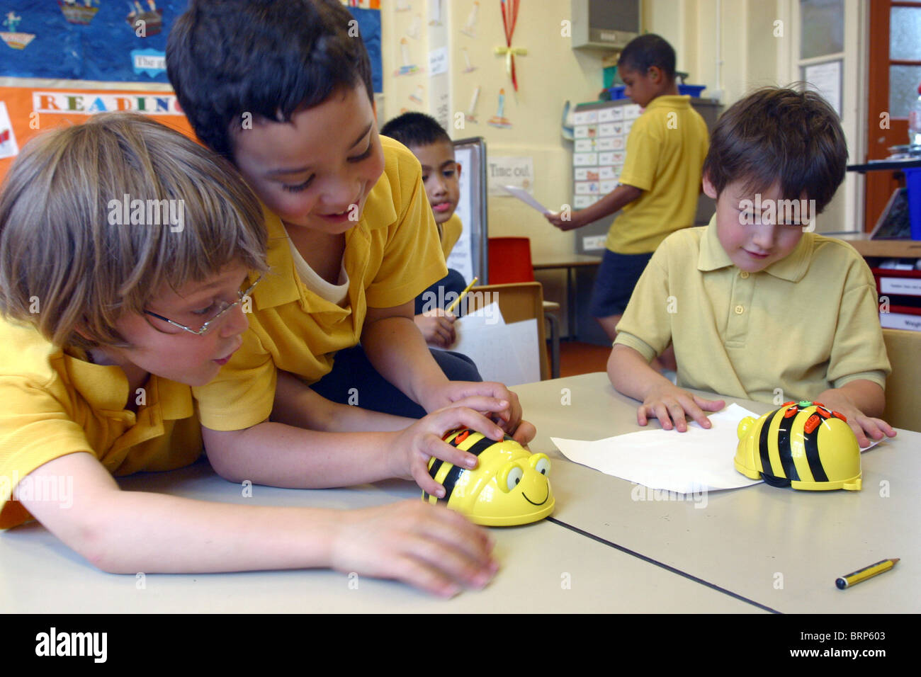 Primary school children in classroom playing with wind up bumble bee