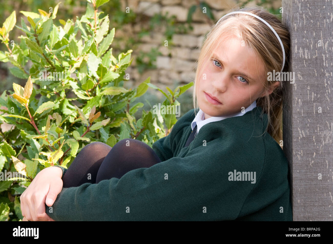 Portrait of a schoolgirl wearing school uniform looking cross, unhappy ...