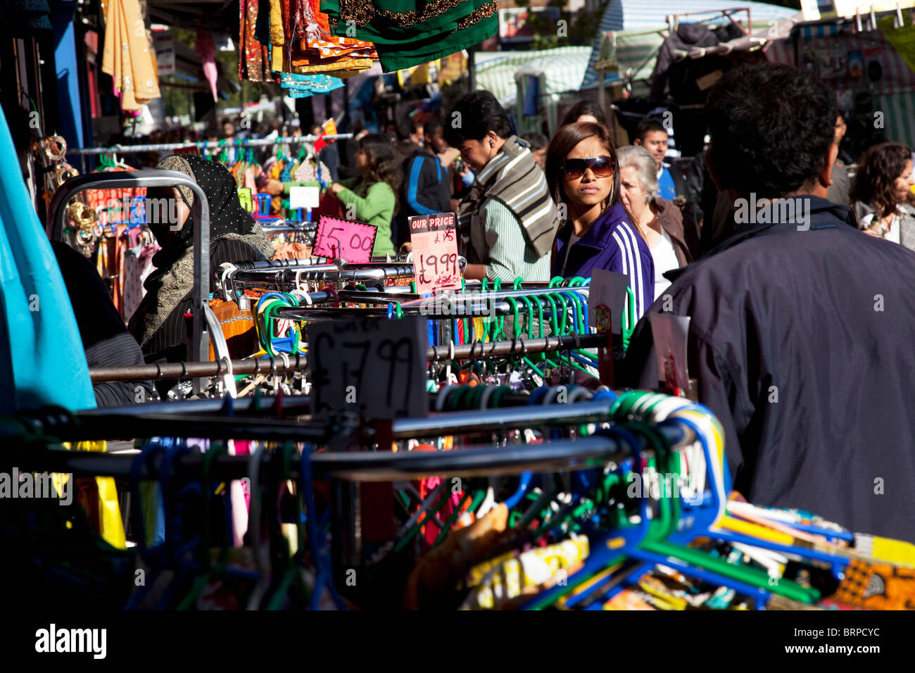 People from various ethnic, predominantly Muslim backgrounds around the market on Whitechapel High Street in East London. Stock Photo