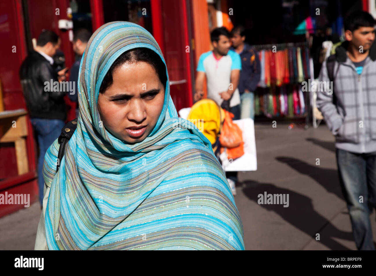 People from various ethnic, predominantly Muslim backgrounds around the market on Whitechapel High Street in East London. Stock Photo