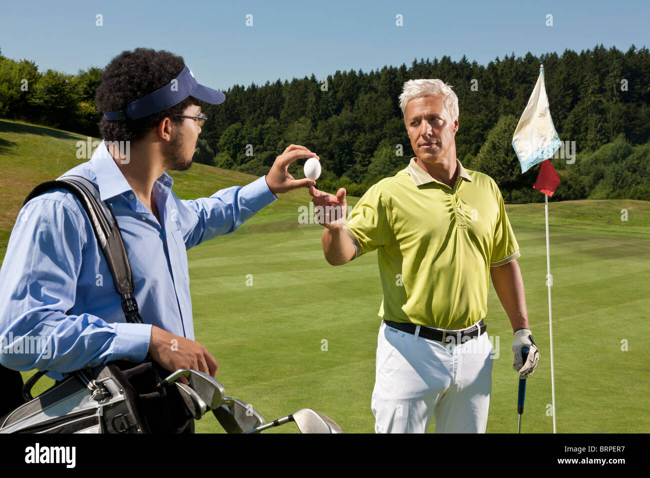 Caddy gives an egg to another golfer Stock Photo