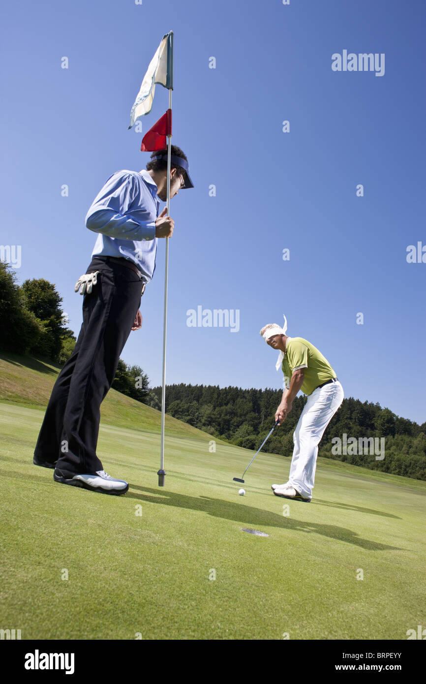 Blindfolded golfing man and Caddy Stock Photo