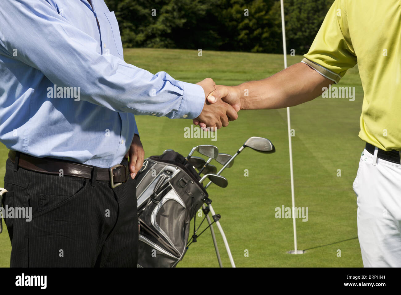 Golfer and caddy shaking hands Stock Photo