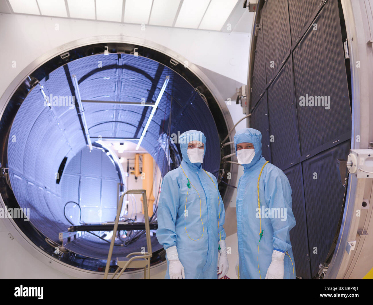 Workers with satellite testing chamber Stock Photo