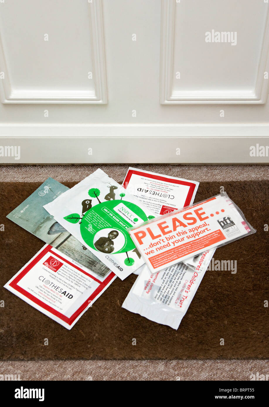 junk mail delivered through letterbox on doormat Stock Photo